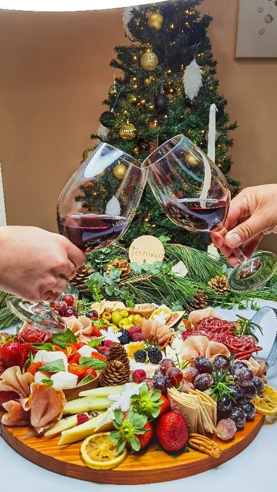 Brindis con vino tinto sobre una mesa de pastoreo navideña